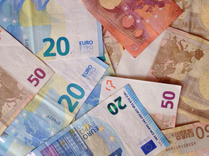 Overlapping euro banknotes of multiple denominations in a colorful collage.